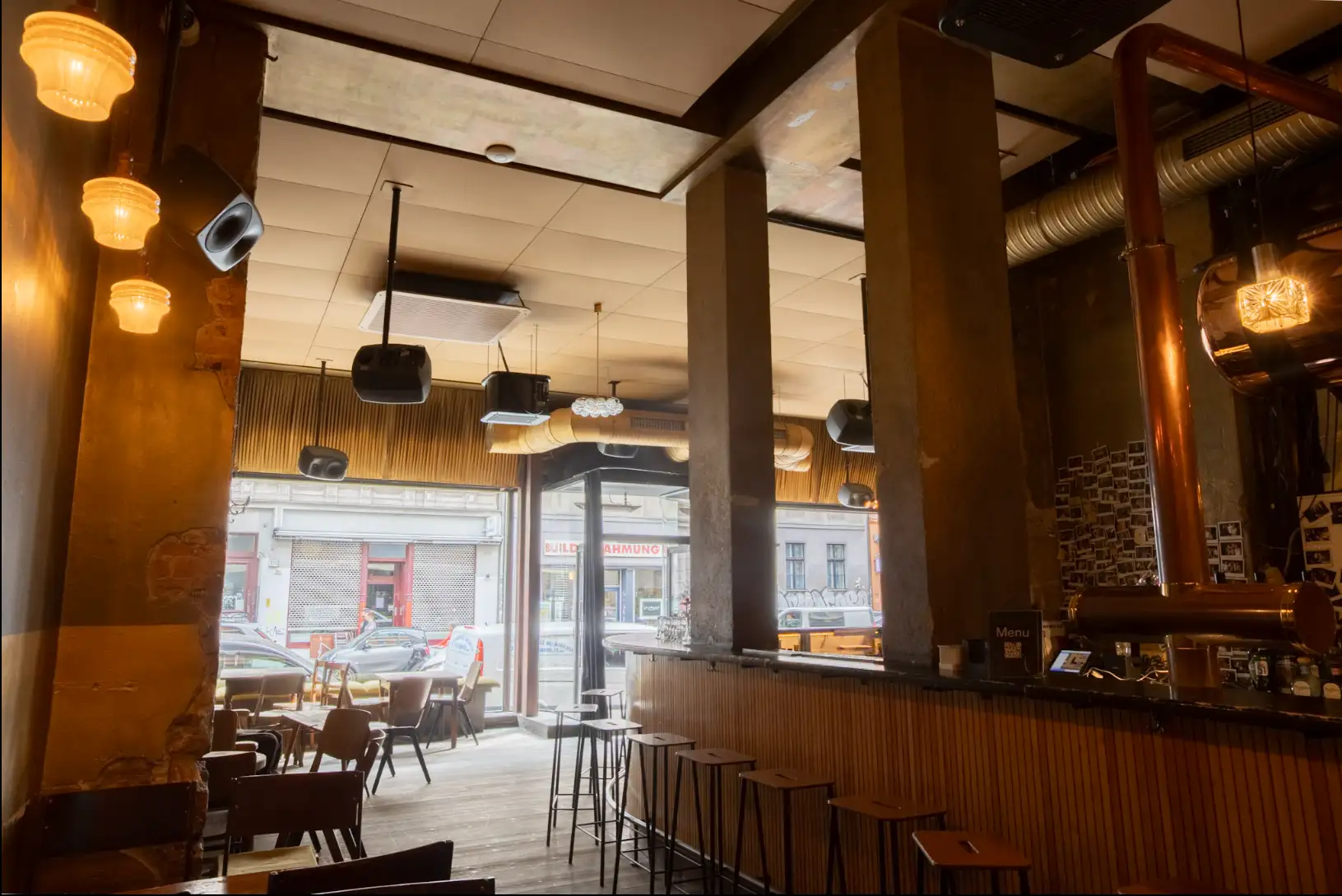 The golden acoustic ceiling and distributed speakers at Café Luzia, Berlin