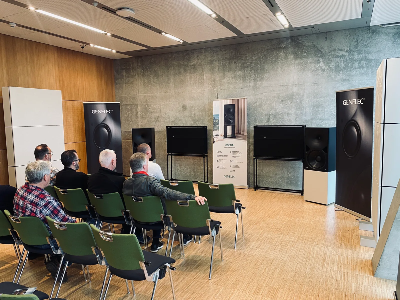 Visitors seated in the 8380A listening room at FINEST AUDIO SHOW Darmstadt, with loudspeakers and ONDSU acoustic panels around the room.